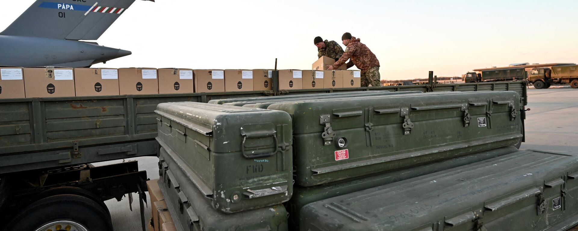 Militares da Ucrânia carregam um caminhão com caixas enquanto mísseis FIM-92 Stinger (dianteiros) fabricados nos EUA e um sistema de defesa aérea portátil (MANPADS) são empilhados após serem enviados para o aeroporto Boryspil em Kiev, 13 de fevereiro de 2022 - Sputnik Brasil, 1920, 02.07.2024