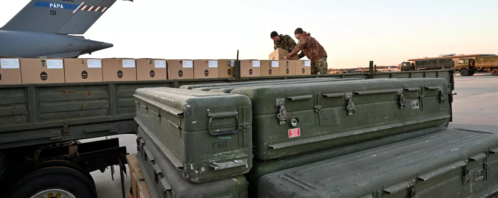 Militares da Ucrânia carregam um caminhão com caixas enquanto mísseis FIM-92 Stinger (dianteiros) fabricados nos EUA e um sistema de defesa aérea portátil (MANPADS) são empilhados após serem enviados para o aeroporto Boryspil em Kiev, 13 de fevereiro de 2022 - Sputnik Brasil, 1920, 02.07.2024