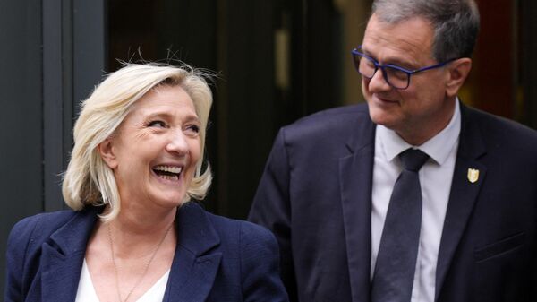 A ex-presidente do bloco político de direita francês Reagrupamento Nacional (RN), Marine Le Pen, e o prefeito de Perpignan, Louis Aliot, deixam a sede do partido em Paris, 2 de julho de 2024 - Sputnik Brasil