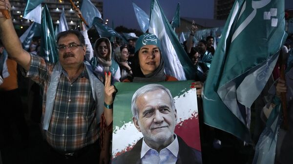 Apoiadores do candidato reformista para a eleição presidencial do Irã, Masoud Pezeshkian, mostrado no pôster, participam de um comício de campanha em Teerã, Irã, 3 de julho de 2024 - Sputnik Brasil