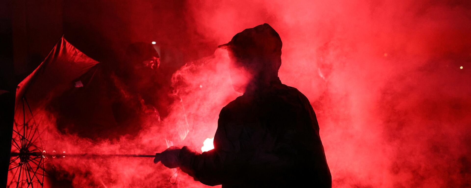 Um manifestante segura um guarda-chuva em uma nuvem de fumaça durante uma reunião na noite após os resultados do segundo turno das eleições legislativas da França na Praça da República, Paris, 8 de julho de 2024 - Sputnik Brasil, 1920, 08.07.2024