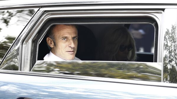 O presidente francês, Emmanuel Macron, no carro com a esposa, Brigitte Macron, após deixar o local de votação para o segundo turno das eleições legislativas. França, 7 de julho de 2024 - Sputnik Brasil