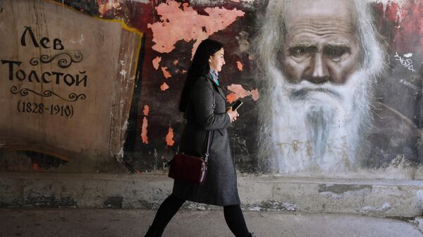 Mulher passa por grafite de Lev Tolstói em uma das ruas de Simferopol, Rússia - Sputnik Brasil