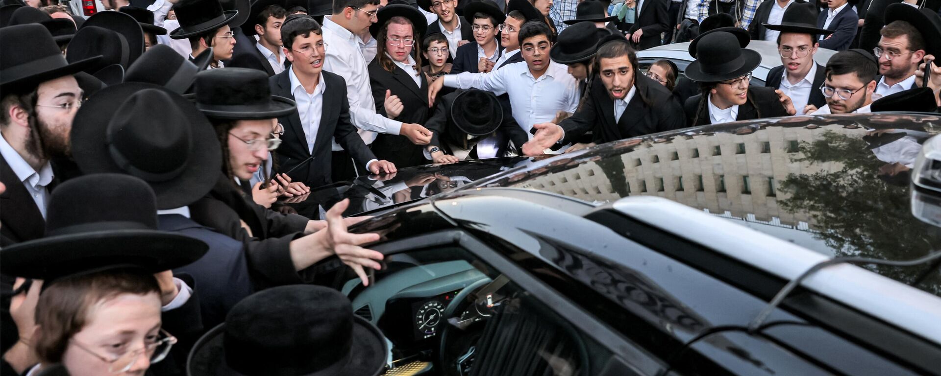 Manifestantes judeus ultraortodoxos se reúnem ao redor do veículo do ministro da Habitação israelense, Yitzhak Goldknopf, durante protesto contra uma decisão do Tribunal Superior de Israel de que eles devem ser convocados para o serviço militar, no distrito de Mea Shearim. Jerusalém, 30 de junho de 2024 - Sputnik Brasil, 1920, 09.07.2024