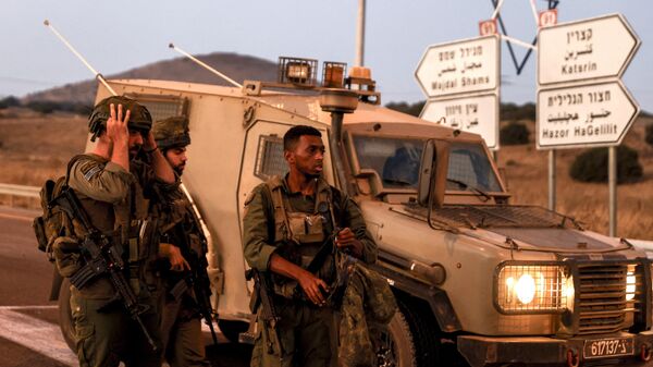 Soldados israelenses protegem estrada enquanto foguetes são lançados do sul do Líbano nas Colinas de Golã anexadas por Israel, em 9 de julho de 2024 - Sputnik Brasil