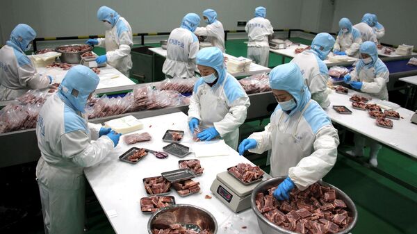 Trabalhadores embalando bife congelado para exportação em uma fábrica de processamento de carne bovina em Binzhou, na província de Shandong, no leste da China - Sputnik Brasil