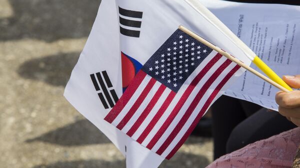 Membro da plateia segura bandeiras dos EUA e da Coreia do Sul na cerimônia de comemoração do 64º aniversário da assinatura do armistício no Memorial dos Veteranos da Guerra da Coreia de Nova Jersey em Atlantic City, Nova Jersey. EUA, 27 de julho de 2017 - Sputnik Brasil