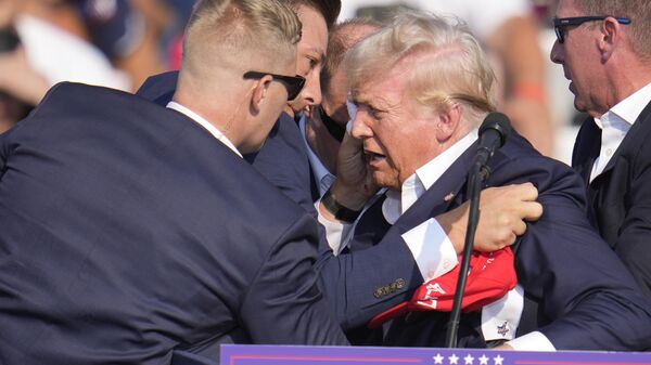 O candidato republicano e ex-presidente Donald Trump é ajudado a sair do palco por agentes do Serviço Secreto dos EUA em um evento de campanha em Butler, Pensilvânia. EUA, 13 de julho de 2024 - Sputnik Brasil