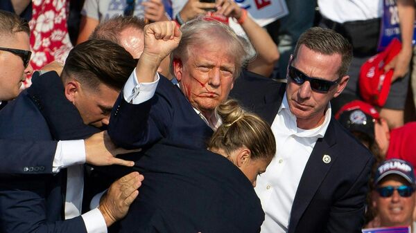 Candidato republicano Donald Trump com sangue no rosto, cercado por agentes do Serviço Secreto norte-americano, é retirado do palco durante evento de campanha na Butler Farm Show Inc., em Butler, Pensilvânia, EUA, 13 de julho de 2024 - Sputnik Brasil