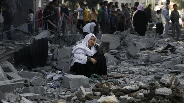 Uma mulher palestina sentada nos escombros após um ataque aéreo israelense no campo de refugiados de Rafah, no sul da Faixa de Gaza, em 18 de novembro de 2012 - Sputnik Brasil