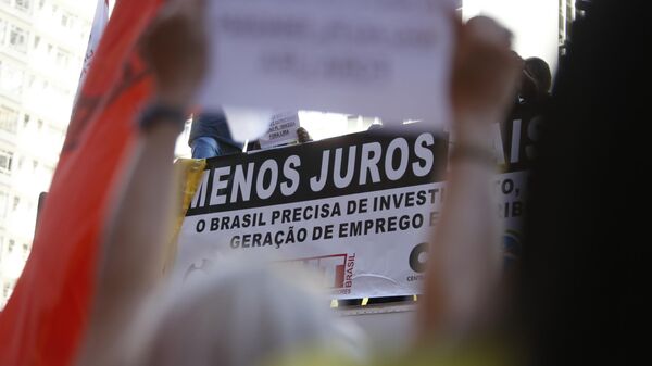Cartaz segurado em frente ao Banco Central por manifestantes em ato das centrais sindicais pede redução da taxa de juros no Brasil. São Paulo, 18 de junho de 2024 - Sputnik Brasil