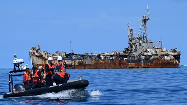 Agentes da guarda costeira filipina e jornalistas navegando a bordo de um barco inflável rígido (E) enquanto retornam após filmar o BRP Sierra Madre atracado em Second Thomas Shoal, no turbulento mar do Sul da China (foto de arquivo) - Sputnik Brasil