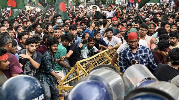 Estudantes ativistas empurram barricadas policiais durante um protesto antes de entregarem seu memorando ao presidente do país sobre reformas de cotas para empregos públicos, em Daca, em 14 de julho de 2024 - Sputnik Brasil