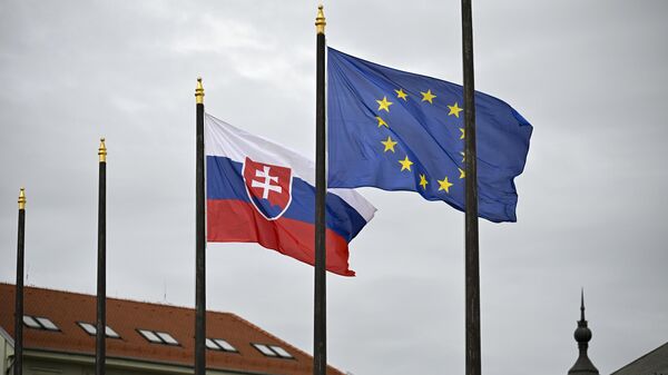 A bandeira nacional eslovaca (E) tremula ao lado da bandeira da União Europeia (UE) em frente ao Palácio Presidencial em Bratislava, Eslováquia, 5 de abril de 2024 - Sputnik Brasil