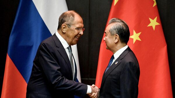 O Ministro das Relações Exteriores da China, Wang Yi (D), aperta a mão do Ministro das Relações Exteriores da Rússia, Sergei Lavrov, durante uma reunião ministerial à margem da 57ª Reunião de Ministros das Relações Exteriores da ASEAN, Vietnã, 25 de julho de 2024 - Sputnik Brasil