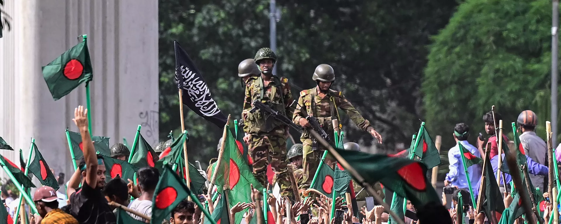 Manifestantes contra o governo marcham em direção ao palácio da primeira-ministra Sheikh Hasina, enquanto os militares ficam de guarda na área de Shahbag, perto da Universidade de Daca, 5 de agosto de 2024. - Sputnik Brasil, 1920, 05.08.2024