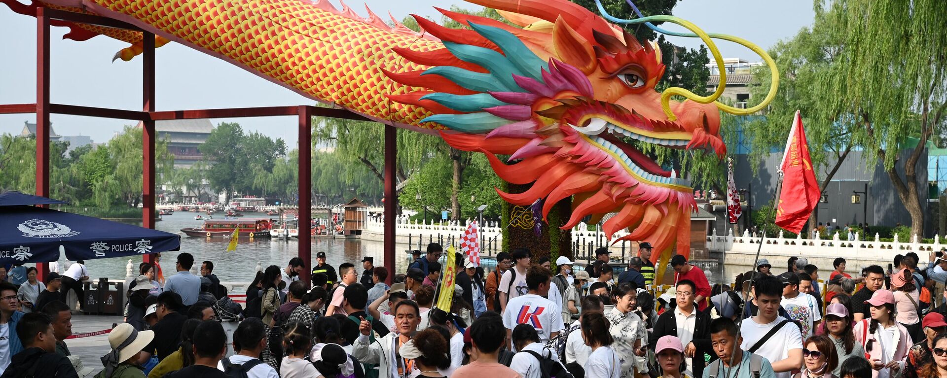 Turistas passam por um dragão gigante em uma área turística em Pequim no quarto dia durante um feriado nacional de cinco dias, 4 de maio de 2024 - Sputnik Brasil, 1920, 05.08.2024