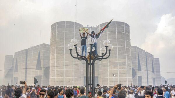 Manifestantes antigoverno celebram do lado de fora do Parlamento de Bangladesh após receberem a notícia da renúncia da primeira-ministra, Sheikh Hasina, em Dhaka. Bangladesh, 5 de agosto de 2024 - Sputnik Brasil