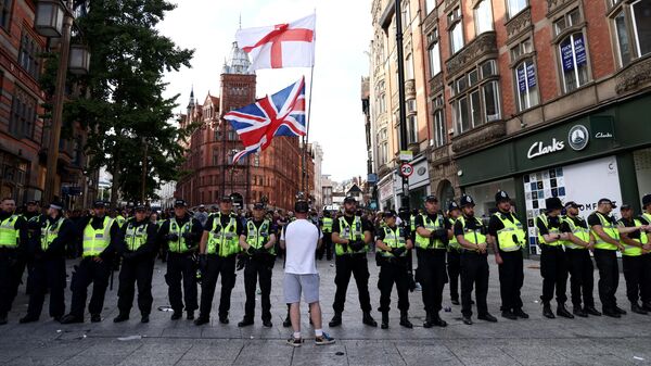 Policiais formam uma fila em frente a contra-manifestantes em Nottingham, centro da Inglaterra, contra a manifestação Basta é Basta realizada em reação aos ataques fatais à faca em Southport de 29 de julho, 3 de agosto de 2024  - Sputnik Brasil