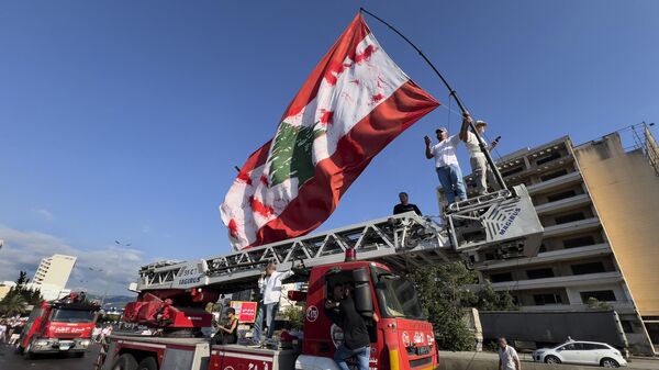 Parentes das vítimas que morreram na explosão mortal no porto de Beirute em 2020 agitam uma bandeira libanesa gigante em Beirute, Líbano, domingo, 4 de agosto de 2024 - Sputnik Brasil