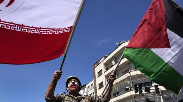 Com o rosto pintado nas cores da bandeira iraniana, um homem chora enquanto agita bandeiras iranianas e palestinas no comício anual para marcar o Dia de Quds, ou Dia de Jerusalém, em apoio aos palestinos, em Teerã, Irã, 5 de abril de 2024 - Sputnik Brasil