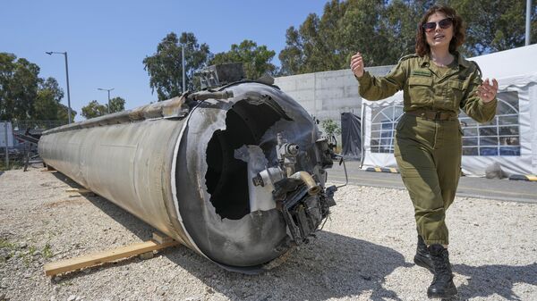 A vice-chefe militar israelense do departamento de imprensa internacional da IDF, primeira-tenente Masha Michelson, exibe à mídia um dos mísseis balísticos iranianos que Israel interceptou no fim de semana, na base militar de Julis, no sul de Israel, terça-feira, 16 de abril de 2024 - Sputnik Brasil