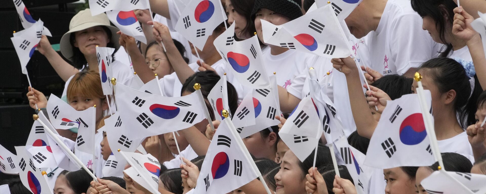 Sul-coreanos agitam bandeiras nacionais durante uma cerimônia para celebrar o Dia da Libertação da Coreia do domínio colonial japonês em 1945, em frente ao pavilhão Bosingak em Seul, Coreia do Sul, 15 de agosto de 2024 - Sputnik Brasil, 1920, 15.08.2024