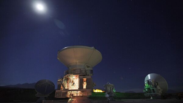 A Lua brilha sobre antenas de rádio na instalação de suporte de operações de um dos maiores projetos de astronomia do mundo, o Atacama Large Millimeter/submillimeter Array (ALMA), no deserto do Atacama, no norte do Chile, 26 de setembro de 2012 - Sputnik Brasil