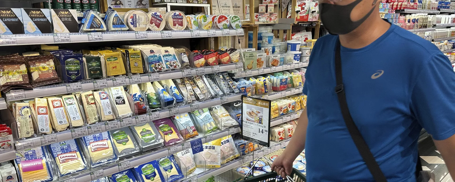 Um homem usando máscara passa por uma prateleira exibindo queijo importado da Europa em um supermercado em Pequim, 21 de agosto de 2024 - Sputnik Brasil, 1920, 21.08.2024