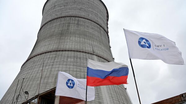 Uma bandeira nacional russa e bandeiras com o logotipo da Rosatom tremulam no canteiro de obras de uma torre de resfriamento na usina nuclear de Kursk II, perto da vila de Makarovka, nos arredores de Kurchatov, região de Kursk, Rússia - Sputnik Brasil