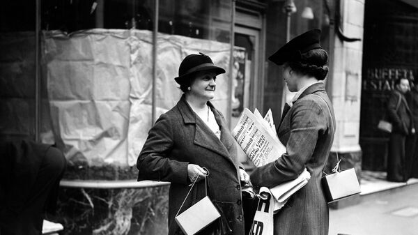 Vendedora de jornais de rua com máscara de gás pendurada em seu estojo nas costas, em Londres, Reino Unido, 4 de setembro de 1939 - Sputnik Brasil