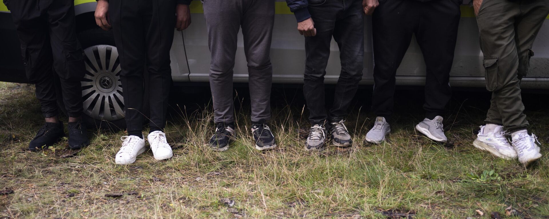 Migrantes esperam em um carro da polícia depois de cruzarem ilegalmente a fronteira da Polônia para a Alemanha e serem rastreados por uma patrulha da Polícia Federal em uma floresta perto de Forst, a sudeste de Berlim, 11 de outubro de 2023 - Sputnik Brasil, 1920, 27.08.2024