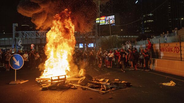 Manifestantes colocaram fogo em madeiras e pneus durante bloqueio de rodovia em ato contra o governo israelense. Tel Aviv, 1º de setembro de 2024 - Sputnik Brasil