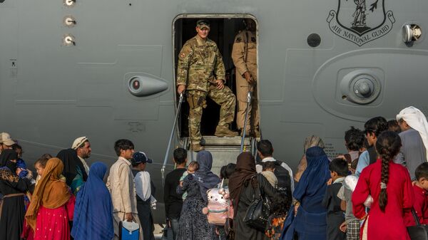 Membros do serviço da Força Aérea dos EUA se preparam para embarcar evacuados em um C-17 Globemaster III na Base Aérea de Al Udeid, no Catar, 22 de agosto de 2021 - Sputnik Brasil