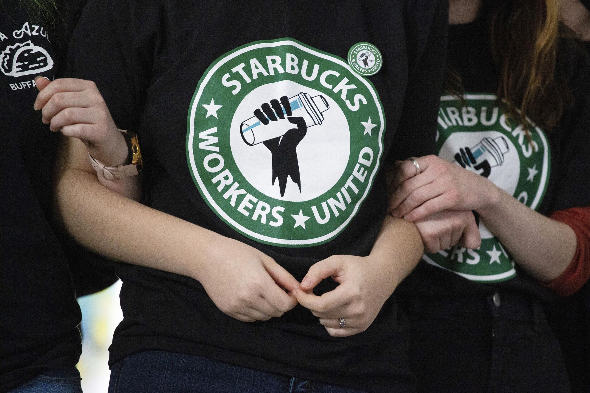 Funcionários e apoiadores da Starbucks dão os braços durante observação da eleição sindical em 9 de dezembro de 2021, em Buffalo, EUA (foto de arquivo)  - Sputnik Brasil, 1920, 06.09.2024