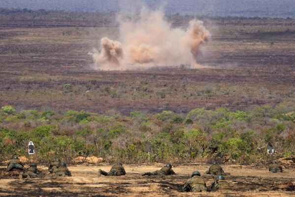 Explosões de artilharia são vistas enquanto soldados fazem movimentação rasteira de terreno durante os exercícios de treinamento da Operação Formosa em Formosa, Brasil, 11 de setembro de 2024. - Sputnik Brasil