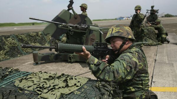 Um soldado da força aérea de Taiwan toma posição de guarda em frente a uma arma antiaérea durante um exercício na base aérea em Chiayi, centro de Taiwan, 24 de agosto de 2010 - Sputnik Brasil