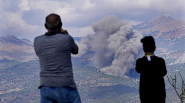 Cidadãos libaneses observam a fumaça dos ataques aéreos israelenses nas montanhas Mahmoudiyeh, vista da cidade de Marjayoun, sul do Líbano, 21 de setembro de 2024 - Sputnik Brasil