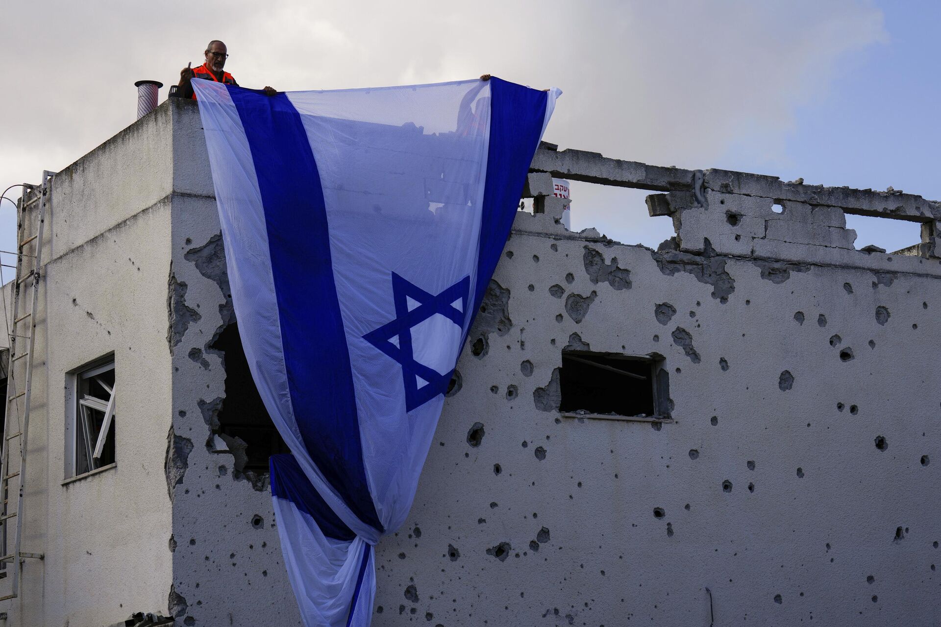 Funcionários da prefeitura penduram uma bandeira israelense sobre prédio atingido por um foguete disparado do Líbano, em Kiryat Bialik, norte de Israel, 22 de setembro de 2024 - Sputnik Brasil, 1920, 03.10.2024