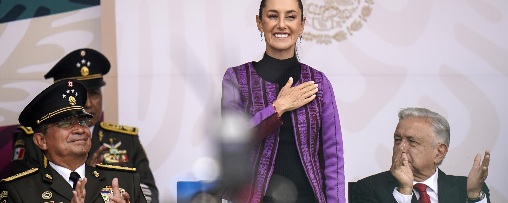 A presidente eleita mexicana, Claudia Sheinbaum, ao lado do secretário de Defesa Nacional, Luis Cresencio Sandoval (à esquerda), e do presidente Andrés Manuel López Obrador (à direita), durante desfile militar do Dia da Independência, no Zócalo, a praça principal da Cidade do México, em 16 de setembro de 2024 - Sputnik Brasil, 1920, 31.10.2024