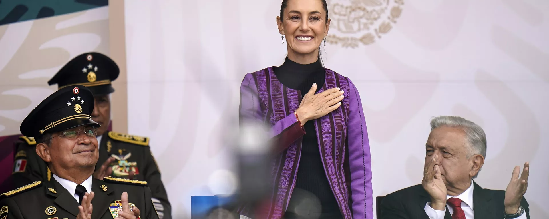 A presidente eleita mexicana, Claudia Sheinbaum, ao lado do secretário de Defesa Nacional, Luis Cresencio Sandoval (à esquerda), e do presidente Andrés Manuel López Obrador (à direita), durante desfile militar do Dia da Independência, no Zócalo, a praça principal da Cidade do México, em 16 de setembro de 2024 - Sputnik Brasil, 1920, 31.10.2024