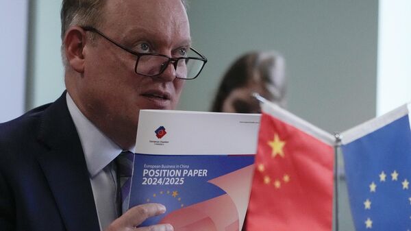 O presidente da Câmara de Comércio da União Europeia na China, Jens Eskelund, segura uma cópia do documento anual de posição da European Business in China durante uma conferência de imprensa em Pequim, 11 de setembro de 2024 - Sputnik Brasil