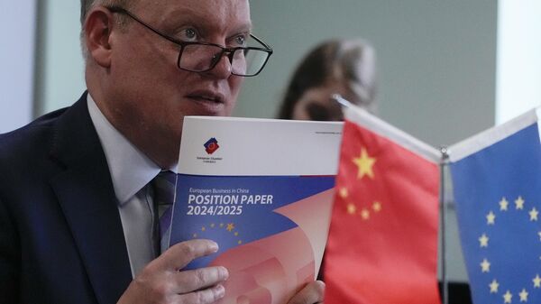 O presidente da Câmara de Comércio da União Europeia na China, Jens Eskelund, segura uma cópia do documento anual de posição da European Business in China durante uma conferência de imprensa em Pequim, 11 de setembro de 2024 - Sputnik Brasil