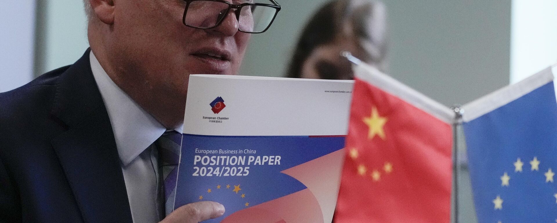 O presidente da Câmara de Comércio da União Europeia na China, Jens Eskelund, segura uma cópia do documento anual de posição da European Business in China durante uma conferência de imprensa em Pequim, 11 de setembro de 2024 - Sputnik Brasil, 1920, 04.10.2024