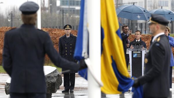 O primeiro-ministro da Suécia, Ulf Kristersson, de centro-direita, fala enquanto militares se preparam para hastear a bandeira da Suécia durante uma cerimônia para marcar a adesão da Suécia à OTAN na sede da OTAN em Bruxelas - Sputnik Brasil