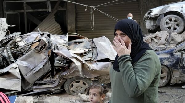 Uma mulher passa na frente de carros destruídos no local de um ataque aéreo israelense de quinta-feira, em Beirute. Líbano, 11 de outubro de 2024 - Sputnik Brasil