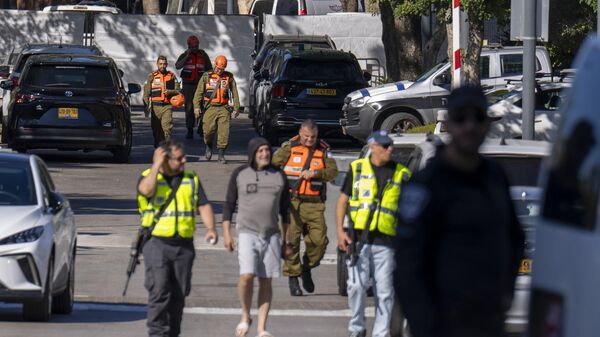 Oficiais da unidade militar do Comando da Frente Interna de Israel caminham em uma estrada perto de onde o governo de Israel diz que um drone foi lançado em direção à casa do primeiro-ministro israelense Benjamin Netanyahu em Cesareia, Israel, 19 de outubro de 2024 - Sputnik Brasil