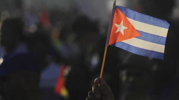 Uma pessoa agita uma bandeira cubana durante ato em celebração ao Dia Internacional dos Trabalhadores, na Praça da Revolução, em Havana. Cuba, 1º de maio de 2024 - Sputnik Brasil