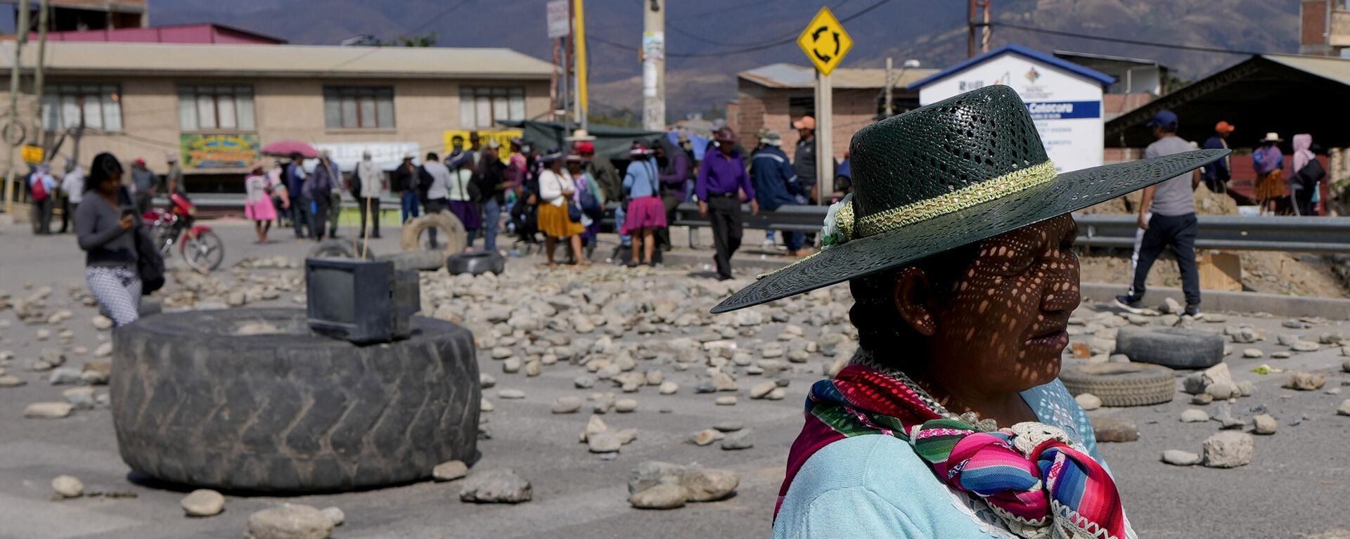 Mulher passa por uma barricada montada por apoiadores do ex-presidente boliviano Evo Morales, que estão bloqueando estradas para impedi-lo de enfrentar uma investigação criminal por um suposto abuso de menor. Cochabamba, Bolívia, novembro de 2024 - Sputnik Brasil, 1920, 01.11.2024