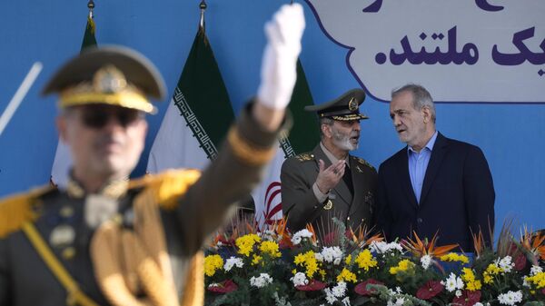 O presidente do Irã, Masoud Pezeshkian, ouve o comandante do Exército iraniano, general Abdolrahim Mousavi, durante o desfile das Forças Armadas que marca o aniversário do início da guerra contra o Iraque, há 44 anos. Teerã, Irã, 21 de setembro de 2024 - Sputnik Brasil